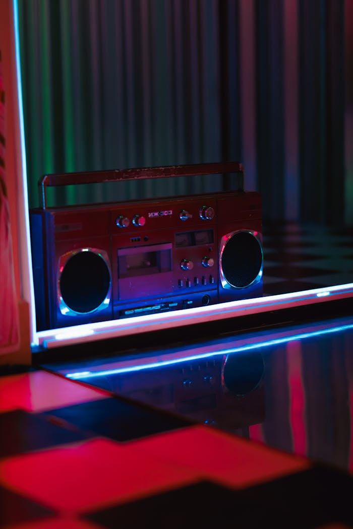 gallery-03 A classic red boombox illuminated by vibrant neon lights inside a nightclub, creating a nostalgic retro vibe.