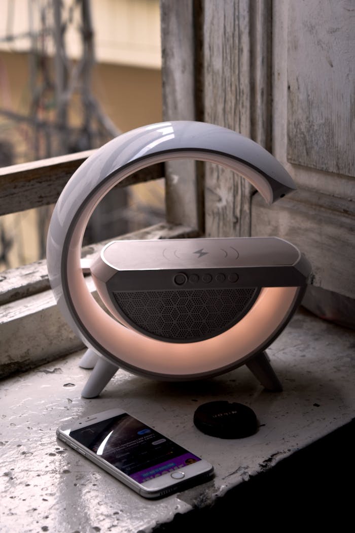 about-img-01 Contemporary speaker with smartphone on rustic windowsill, blending vintage and modern aesthetics.